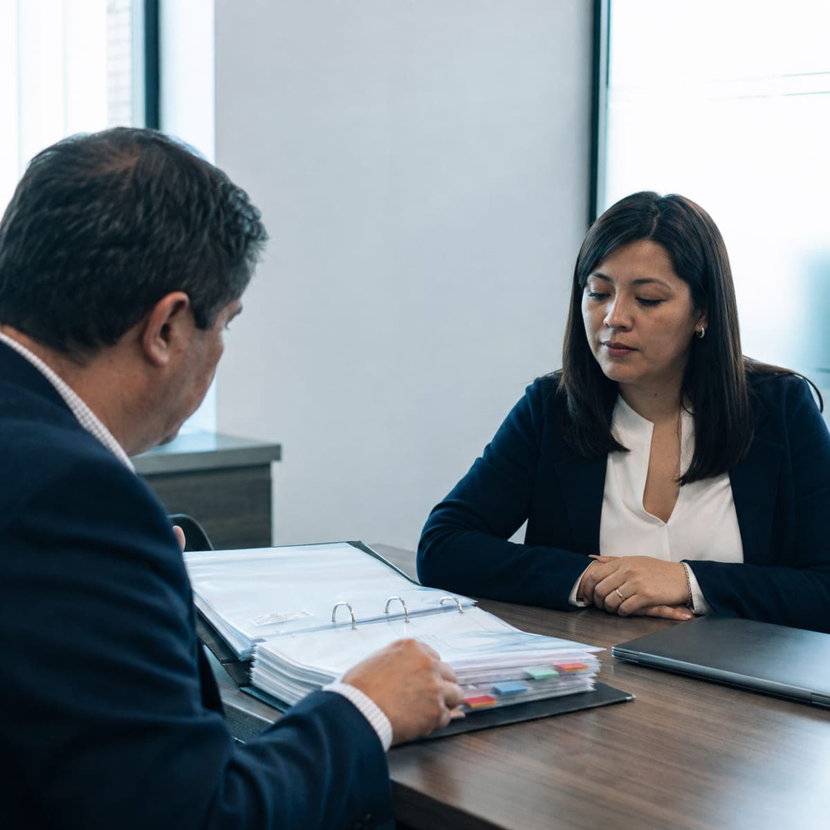 Fiscalizador revisando una carpeta ordenada de registros laborales frente a la encargada de personas de la empresa